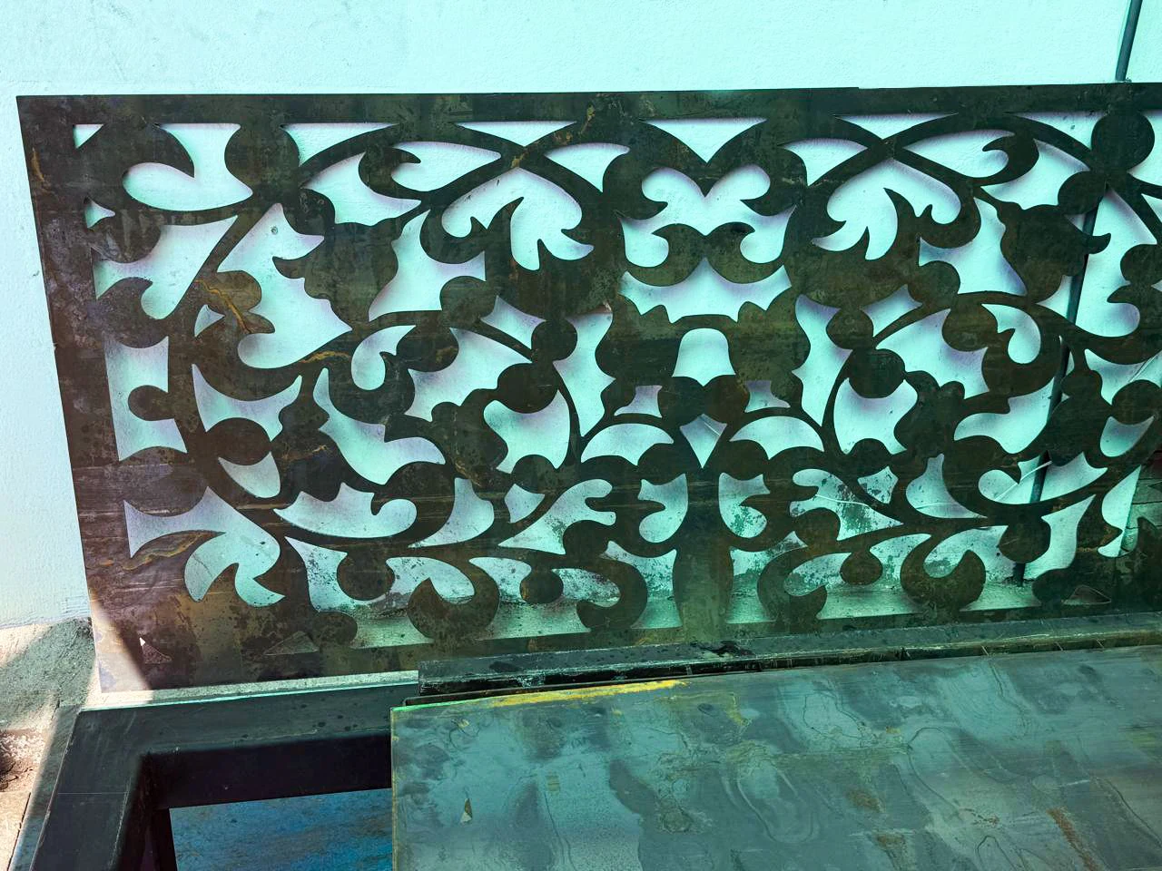 Celosía de acero con diseño floral cortada en plasma y pintada en verde azulado