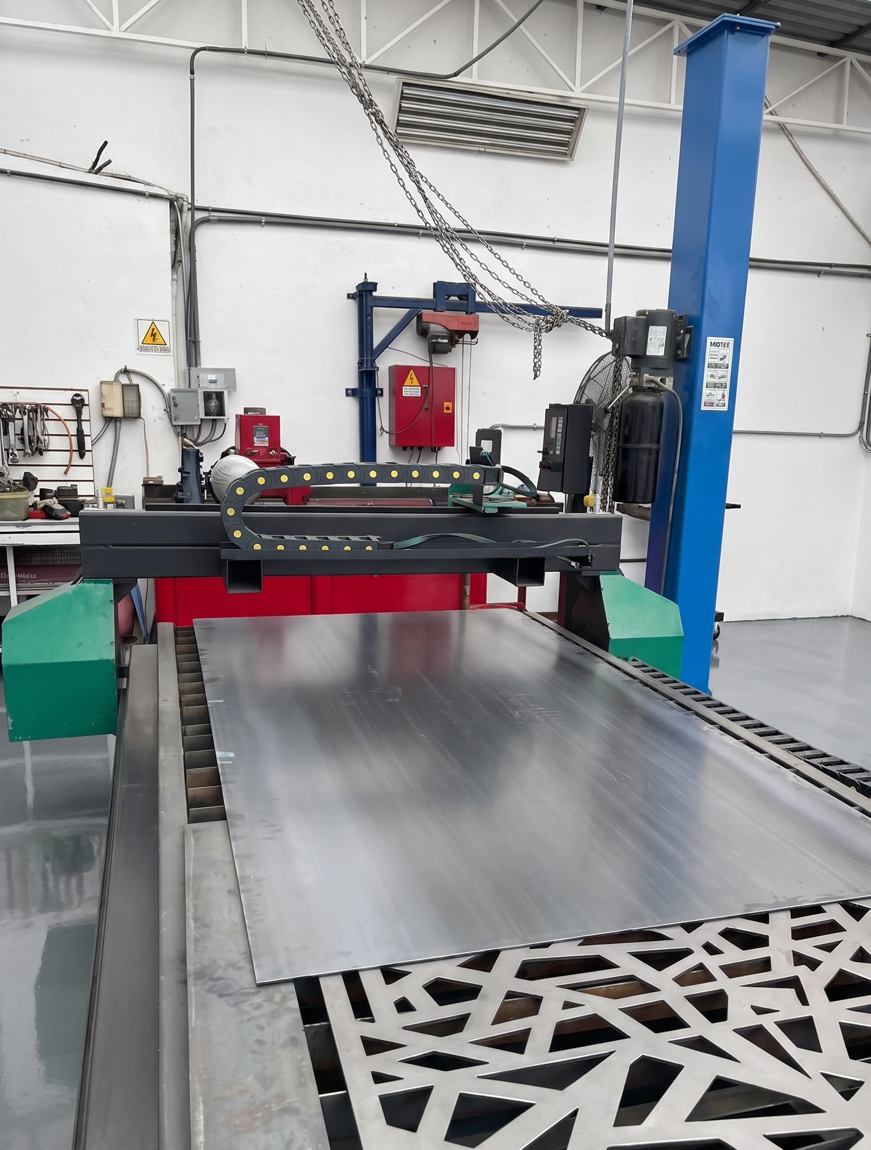 Placa de acero sobre la mesa de la máquina con una celosía de patrón geométrico ya cortada