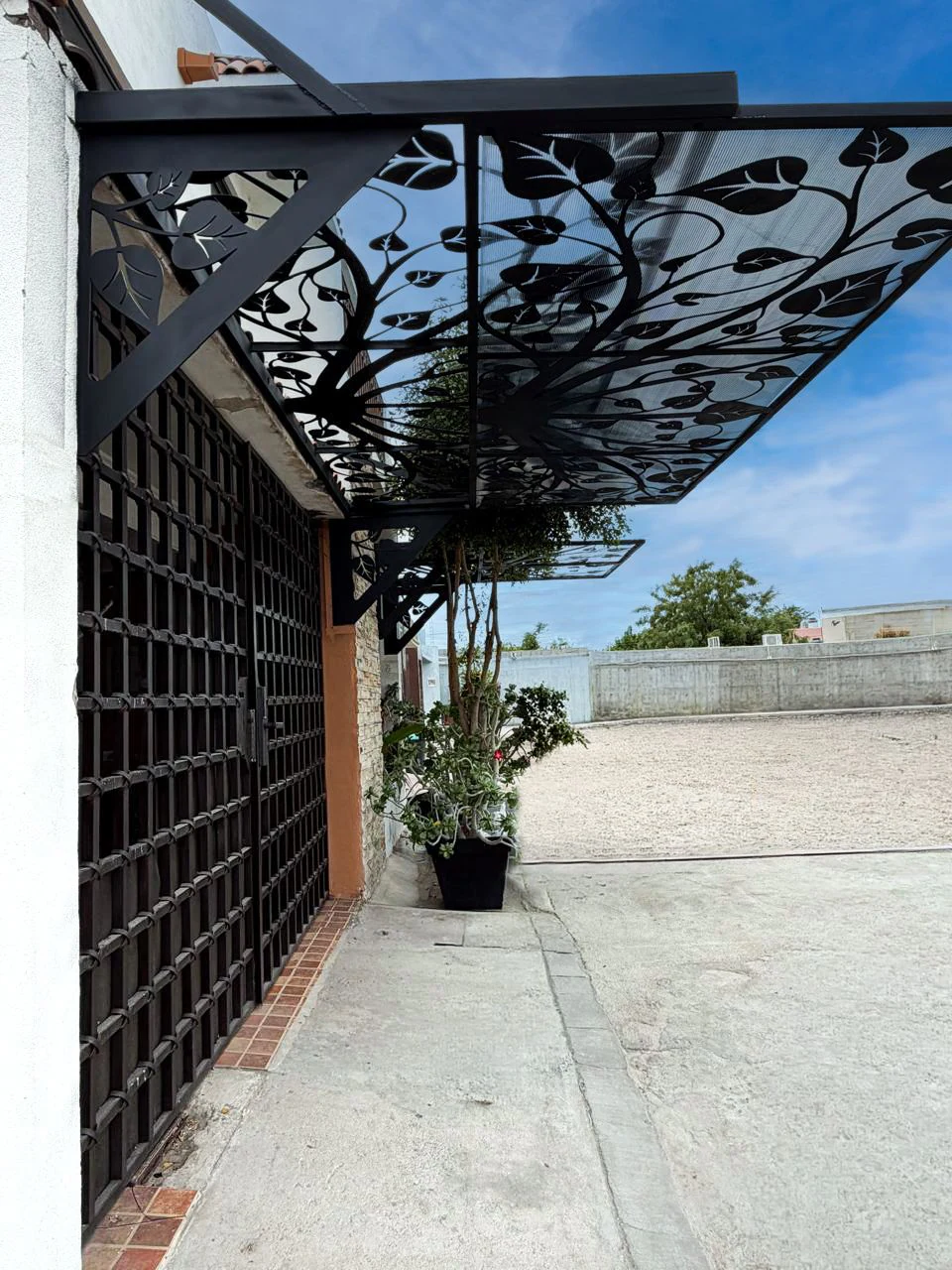 Techo de celosía metálica y reja instalados en un pasillo exterior